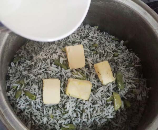 قرار دادن کره روی برنج و افزودن آب 