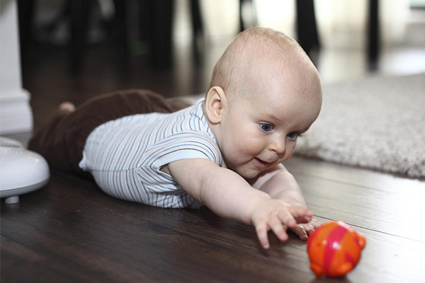 یک اسباب بازی رنگی جلوی نوزاد بگذارید تا برای رسیدن به آن تلاش کند