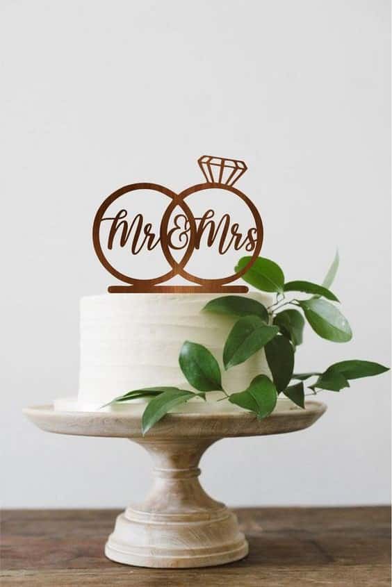 مدل کیک عروسی یک طبقه ساده و شیک تزیین شده با تاپر حلقه و برگ 
