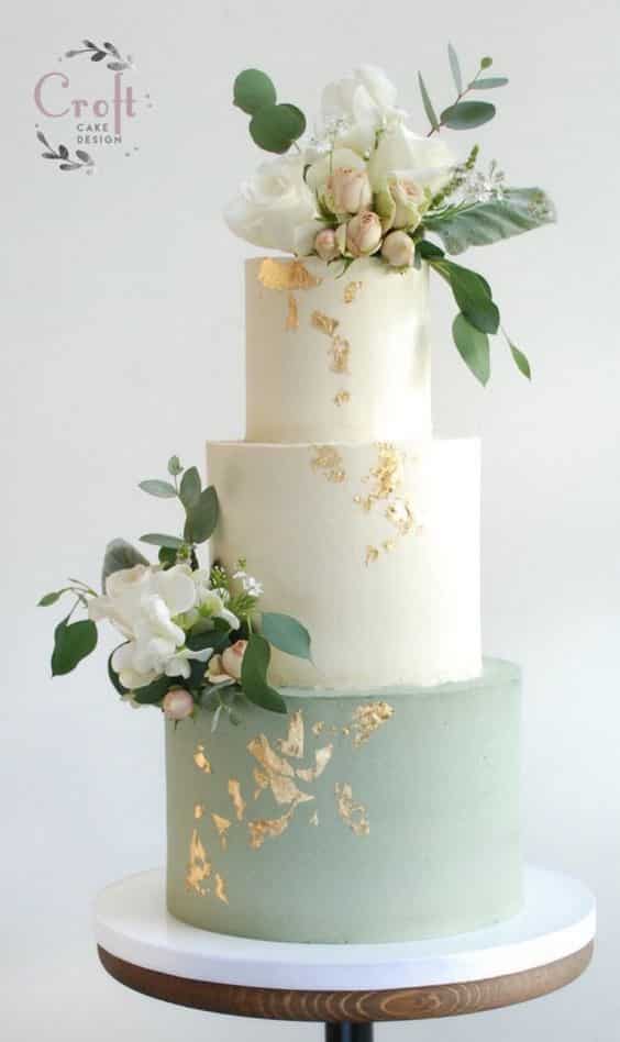 مدل کیک عروسی خامه ای سه طبقه سفید و آبی با تزیین گل طبیعی  