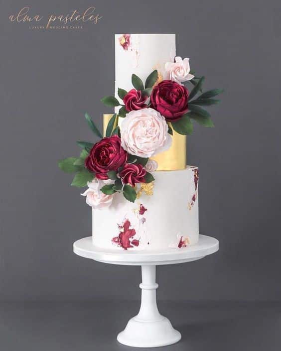 مدل کیک عروسی سه طبقه سفید و طلایی با تزیین گل  