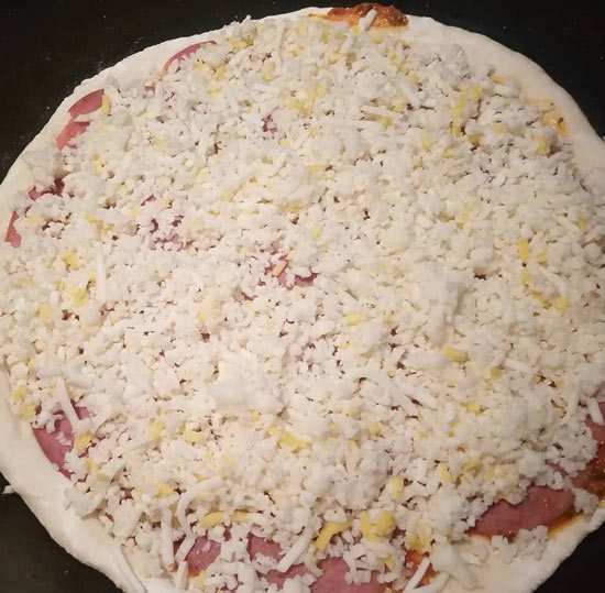 پنیر پیتزا روی طبقه اول پیتزا