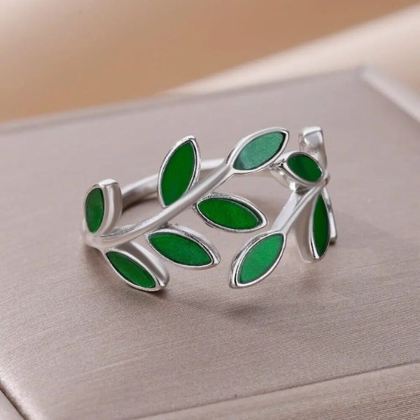 حلقه استیل نقره‌ای رنگ با برگ‌های سبز