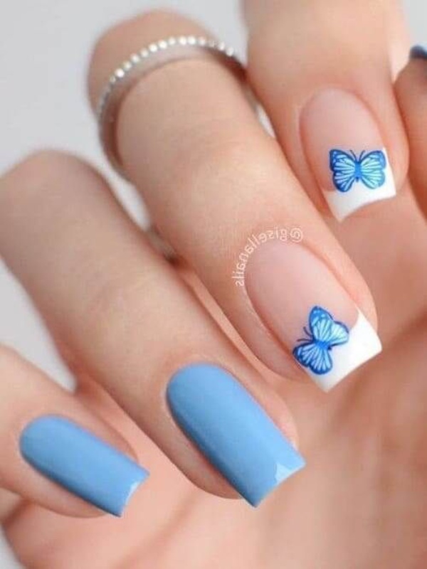 فرنچ سفید ناخن با طرح پروانه آبی و ناخن‌های آبی کمرنگ