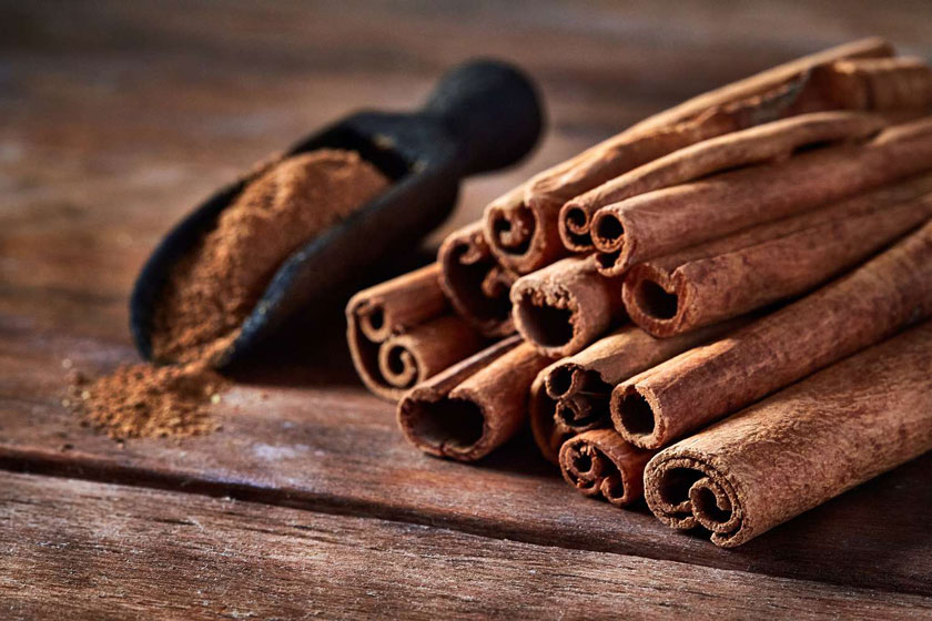 A pile of cinnamon sticks and a scoop of powderAI-generated content may be incorrect.