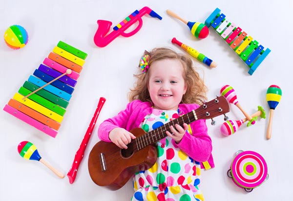 دختر بچه در حال نواختن گیتار - چه سازی برای کودکان مناسب است؟