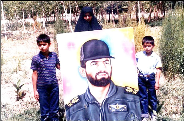 پسران شهید عباس بابایی در کنار عکس پدر 