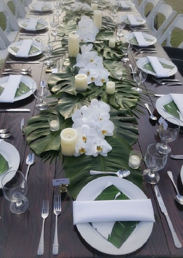 تزیین میز نهار خوری برای مهمانی‌های ساده با گل، برگ و شمع