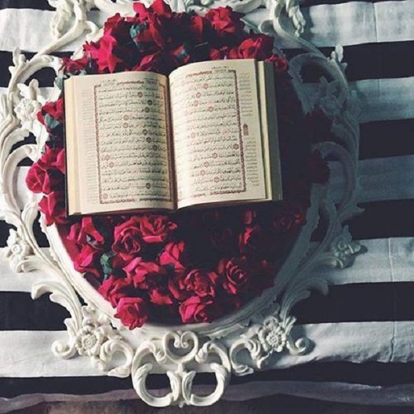 تزیین قرآن سفره عقد با قرار دادن آن گل روی دسته‌ای از گل رز