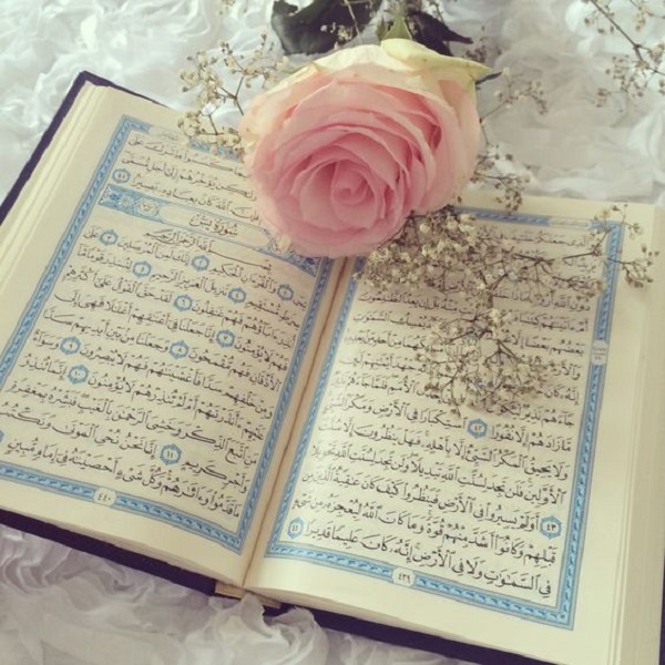 تزیین قرآن سفره عقد با  گل در آن روی پارچه سفید