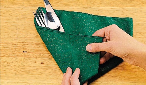 ضلع سمت چپ دستمال را روی کارد و چنگال‌ها قرار دهید.