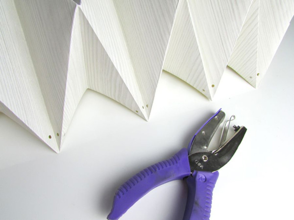 سوراخ کردن گوشه‌ها برای ساخت لوستر با کاغذ دیواری به روش اوریگامی
