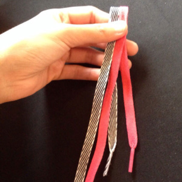 تا کردن دو بند کفش برای ساخت دستبند با بند کفش