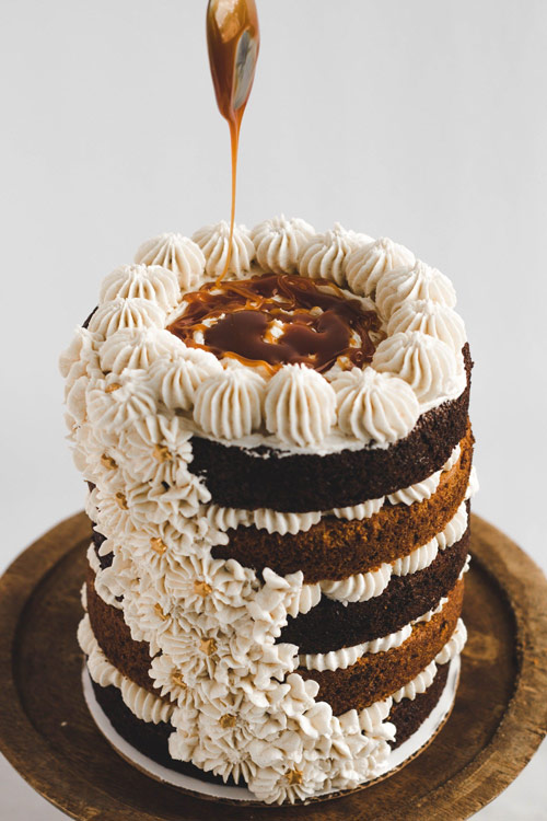 تزیین کیک شکلاتی چندطبقه با خامه و مروارید به شکل گل
